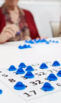 Een spelletje bingo gespeeld met blauwe bingojetons